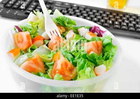 closeup of a salad in a plastic container on the desk of an office Stock Photo