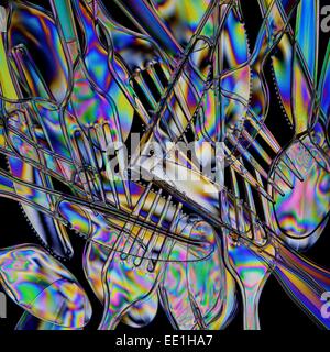 A pile of clear plastic cutlery photographed through polarising filters. Stock Photo