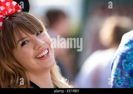 A young lady with Minny Mouse ears and bow in her hair. Stock Photo