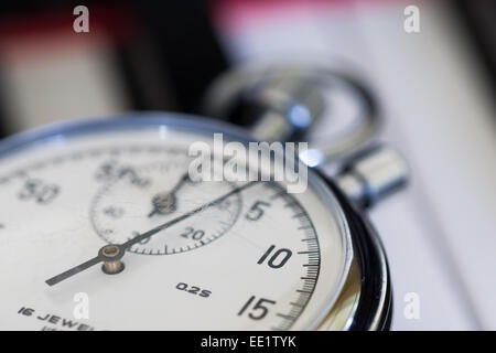 old silver chrome stopwatch with seconds and minute hands 5 second count down chronological timer glass dial buttons against Stock Photo