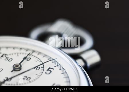 old silver chrome stopwatch with seconds and minute hands 5 second count down chronological timer glass dial buttons against Stock Photo