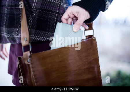 Pickpocket Stealing a Wallet from a Leather Bag Stock Photo