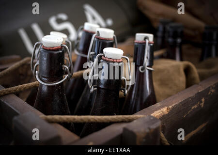 Old vintage beer bottles in a wooden crate with a grunge effect. Stock Photo