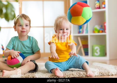 children playing with soft ball in playroom Stock Photo