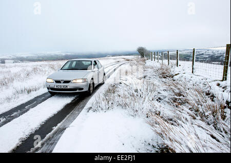 Mynydd Epynt Range of hills, Powys, Wales, UK. 13th January, 2015.  A car negotiates a narrow road on the Epynt range of hills in Powys. Snow falls in Mid Wales as predicted by the weather forecasts. Credit:  Graham M. Lawrence/Alamy Live News. Stock Photo