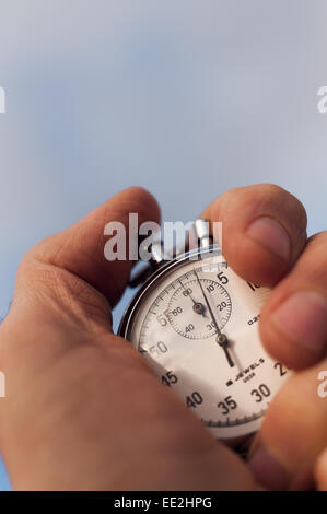 old silver chrome stopwatch with seconds and minute hands 5 second count down chronological timer glass dial buttons against Stock Photo