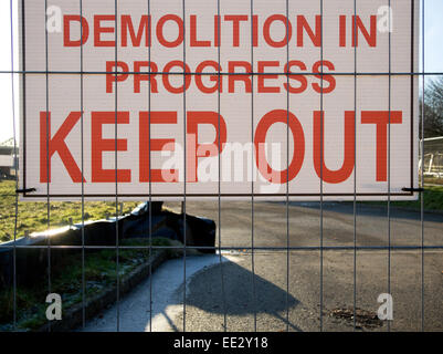 A 'Demolition in progress. Keep out!' sign on a fence at a house building site in Watchfield, Oxfordshire,UK Stock Photo