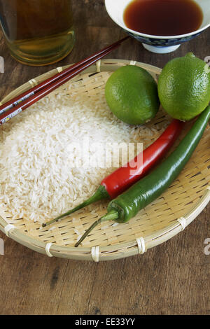 Limes, chilli's, rice and nampla fish sauce, Asian food ingredients Stock Photo