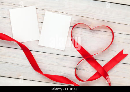 Photo frame cards with valentines heart shaped ribbon over wooden table background Stock Photo