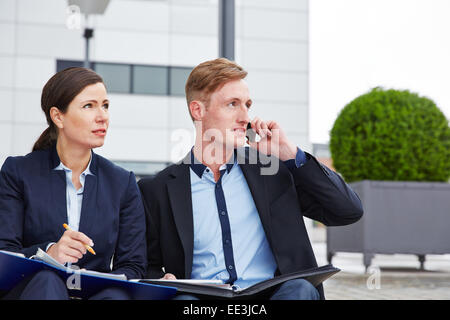 Two successful business people working outdoors in the city Stock Photo