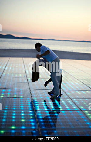 Solar panels as a dance floor, sunset in background Stock Photo