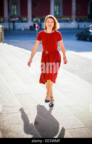 Senior woman walking up staircase, Munich, Bavaria, Germany Stock Photo