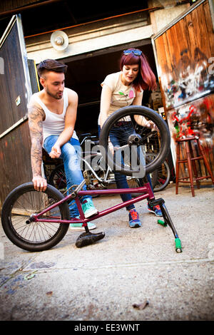 Young couple in workshop repairs bicycle Stock Photo