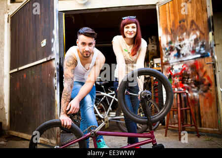 Young couple in workshop repairs bicycle Stock Photo