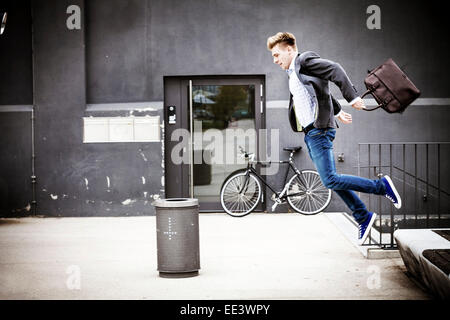 Young businessman jumping in air, Munich, Bavaria, Germany Stock Photo