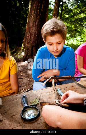 Children crafting in a forest camp, Munich, Bavaria, Germany Stock Photo