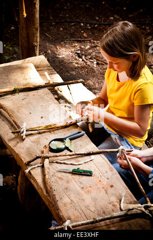 Girl crafting in a forest camp, Munich, Bavaria, Germany Stock Photo