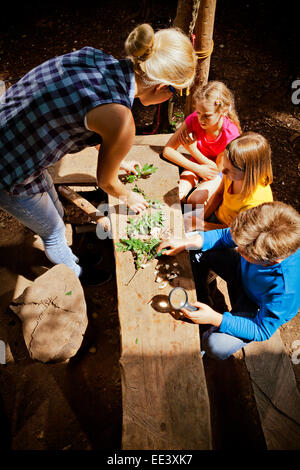 Children and teacher in a forest camp, Munich, Bavaria, Germany Stock Photo