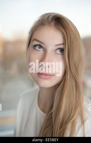 Close up portrait of an attractive teen girl. She is rolling her eyes up and looking. Stock Photo