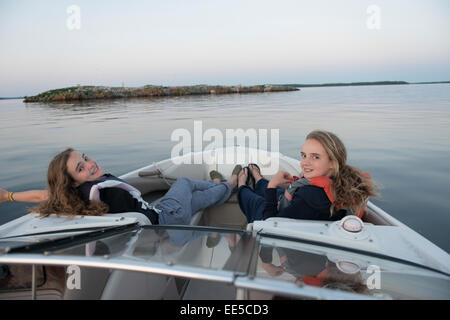 Girls relaxing on a boat, Lake of The Woods, Kenora, Lake of The Woods, Ontario, Canada Stock Photo