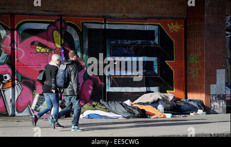 Brighton UK - People pass by boxes and bedding belonging to rough sleepers under the entrance of The Astoria in Brighton Stock Photo