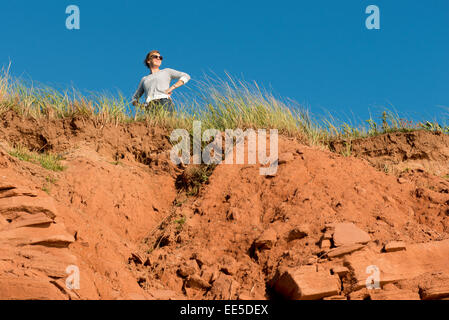 Woman standing on top of cliff, Green Gables, Cavendish, Prince Edward Island, Canada Stock Photo