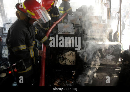 Dhaka, Bangladesh. 14th Jan, 2015. Firefighters try to extinguish fire of a burning bus during the nonstop blockade called by Bangladesh Nationalist Party (BNP) in Dhaka, Bangladesh, Jan. 14, 2015. With the death of four more people Wednesday, the number of deaths reached 17 on the ninth day of the opposition-led indefinite blockade in Bangladesh. Credit:  Shariful Islam/Xinhua/Alamy Live News Stock Photo