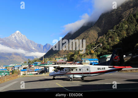 Propeller airplane taking off from Lukla Tenzing Hillary airport, a dramatic mountain runway in the Himalayas Khumbu Himal Nepal Stock Photo