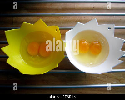 two double yoke eggs in poaching cups Stock Photo