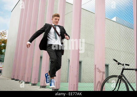 Young businessman jumping in air, Munich, Bavaria, Germany Stock Photo