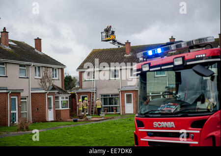 Haverfordwest, UK Wednesday 14 January 2015  Firemen inspect roofs  Two people were taken to hospital after a mini-tornado struck a row of houses in Haverfordwest, Pembrokeshire Stock Photo