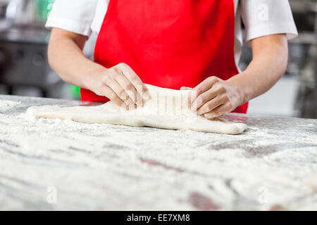 Chef Kneading Dough In Commercial Kitchen Stock Photo