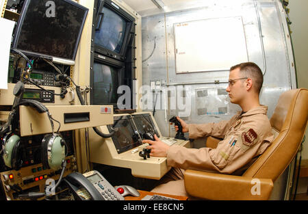 Airman 1st Class Kyle Bridges conducting a surveillance or reconnaissance missions remotely operating a RQ-1 Predator from the operator console at the Unmanned Aerial Vehicle ground control station at Balad Air Base, Iraq. See description for more information. Stock Photo