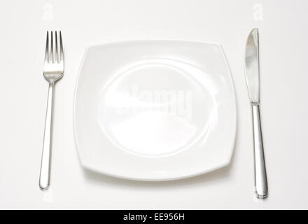 Empty plate with fork and knife over white background Stock Photo