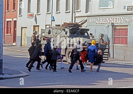 BELFAST, NORTHERN IRELAND - OCTOBER 1972. Families passing British Army Troops on streets of Belfast during The Troubles, Northern Ireland. Stock Photo