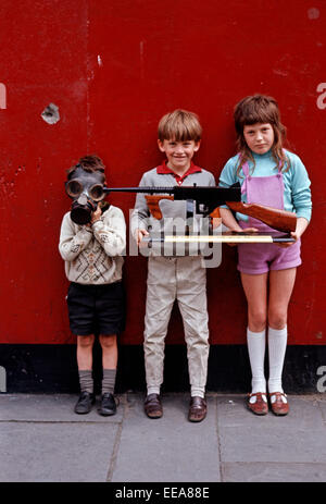 INTERNMENT ART, LONG KESH,NORTHERN IRELAND - JUNE 1972. Children holding Wooden Replica of a Thompson Machine Gun made by Long Kesh Prisoners during The Troubles. Stock Photo