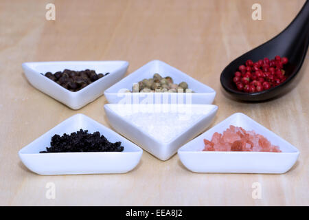 Variety of peppercorns and salt on a table Stock Photo