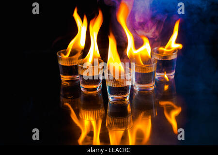 Glasses with burning alcohol on  black background Stock Photo