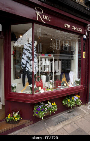 UK, London, Twickenham, Church Street, geraniums in planters outside clothes shop Stock Photo