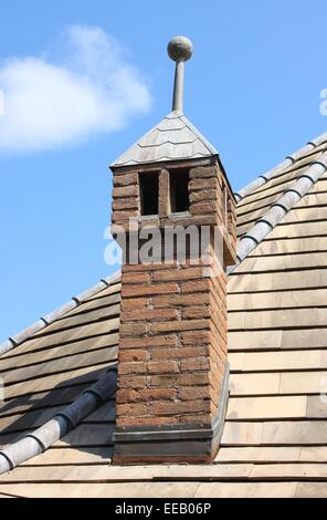 Old traditional rooftop chimney constructed of bricks on a traditional medieval house Stock Photo