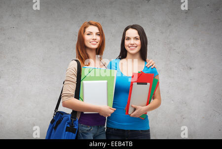two smiling students with bag, folders and tablet Stock Photo