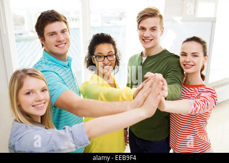 five smiling students giving high five at school Stock Photo