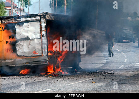 BELFAST, NORTHERN IRELAND - JUNE 1972. British Army attending burning hijacked vehicle in West Belfast during The Troubles, Northern Ireland. Stock Photo