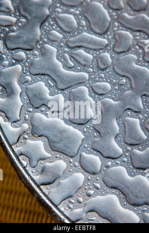 Pooled water effect on the top of a stainless steel table. Stock Photo