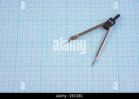 Compasses on graph paper background Stock Photo