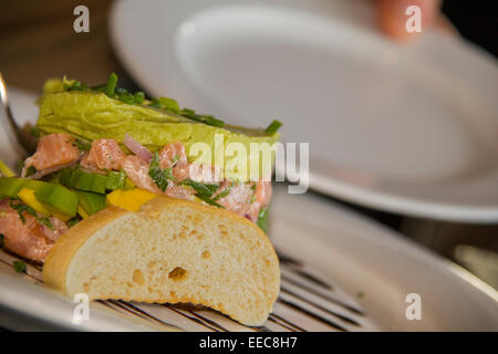 Closeup view of Raw salmon tartar with toasted bread on the plate Stock Photo