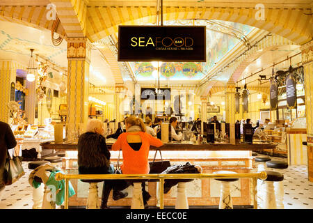 People eating at the Seafood and Sushi Bar, Harrods department store Knightsbridge London; the department in the interior, UK Stock Photo