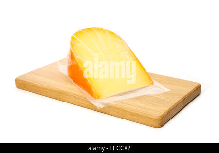 Cheese in vacuum packing on cutting board against white background Stock Photo