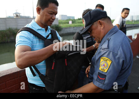 Manila, Philippines. 15th January, 2015. Police inspects the bag of a man around Baclaran to secure Pope Francis arrival. The Pope is visiting the Philippines from January 15 to 19. © Mark Cristino/Pacific Press/Alamy Live News Stock Photo