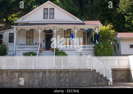 Quaint wooden white picket fence house in Occidental Northern California USA with Halloween pumpkins on porch Stock Photo